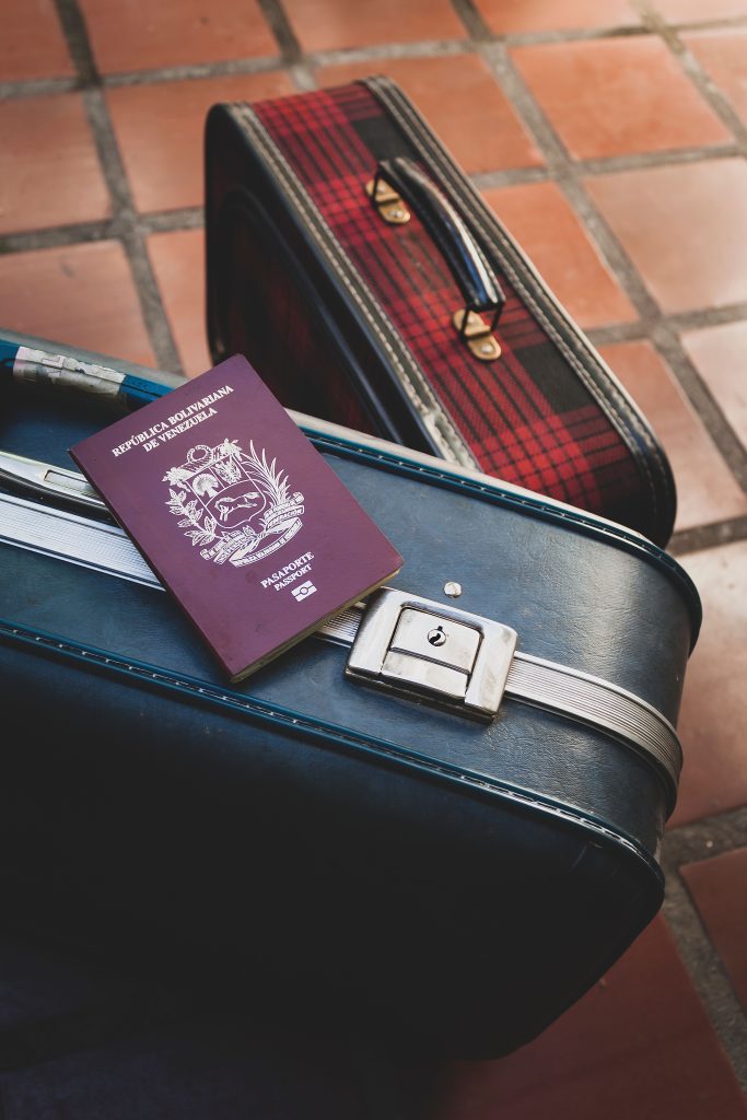 pexels-photo-14545897-14545897 Venezuelan passport resting on vintage suitcases, ideal travel concept imagery for vacation and adventure themes.